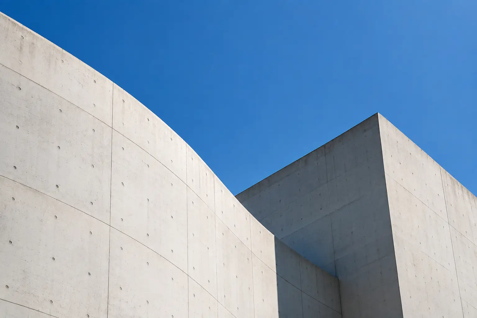 Geometric white architecture beneath a clear blue sky